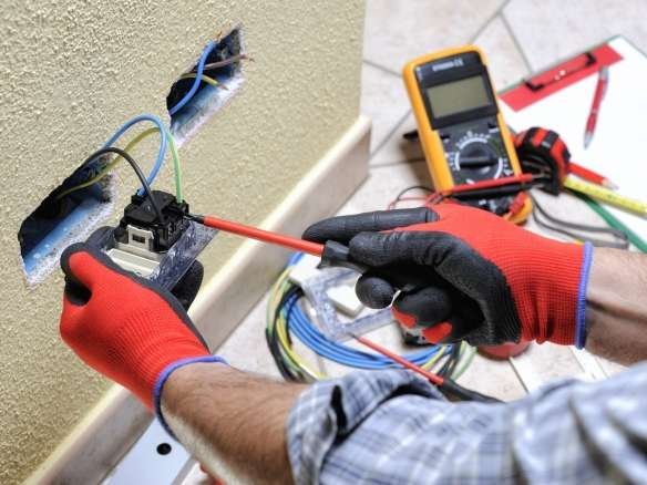 Electrician technician at work with safety equipment on a residential electrical system